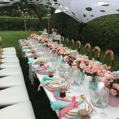 a long table is set up with pink and blue flowers