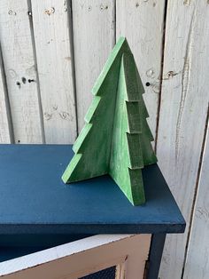 a small wooden christmas tree sitting on top of a blue table