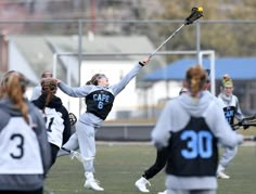 a group of young women playing a game of lacrosse