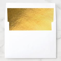 a white envelope with gold foil on it