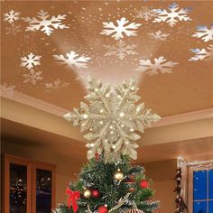 a decorated christmas tree with snowflakes on the ceiling