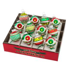 twelve christmas ornaments in a box on display