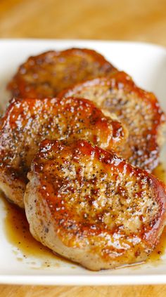 two pieces of meat sitting on top of a white plate covered in ketchup