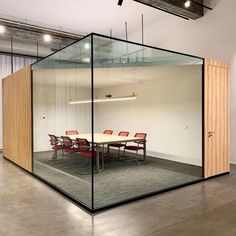 an empty conference room with glass walls and red chairs