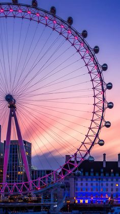 the ferris wheel is lit up at night