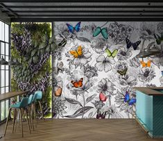 a kitchen with butterflies on the wall and wooden flooring, along with blue bar stools