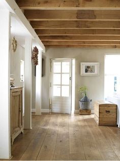 an empty room with wood floors and white walls is pictured in this image, there are two doors that lead into the bedroom