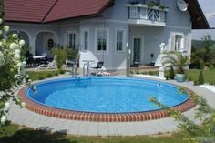 a house with a swimming pool in the front yard and patio area next to it