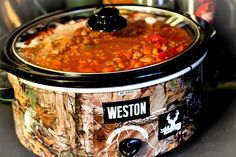 a crock pot filled with meat and vegetables sitting on top of a countertop