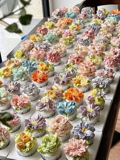 there are many cupcakes that have flowers on them in the shape of flowers