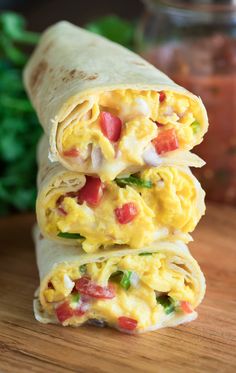 two burritos stacked on top of each other with eggs and veggies