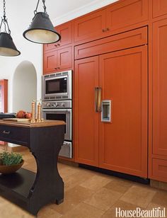 a kitchen with orange cabinets and an island