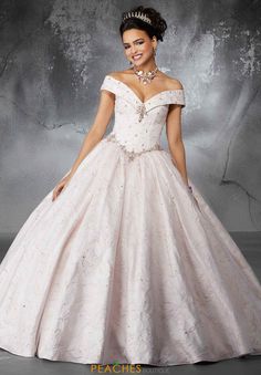 a woman in a ball gown posing for the camera with her hand on her hip