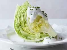 a white plate topped with lettuce covered in sour cream