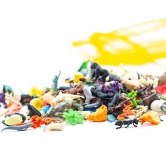 a pile of small toy figurines sitting on top of a table next to a yellow object