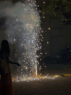 a woman standing in front of a firework display