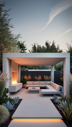 an outdoor living area with couches, tables and fire pit in the middle of it