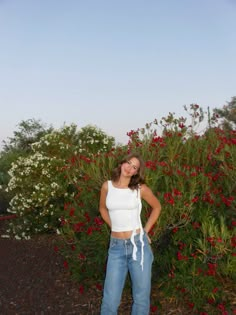 a woman standing in front of some flowers