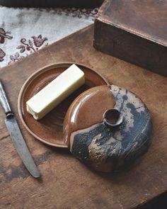 a plate with some food on it next to a knife and a piece of butter