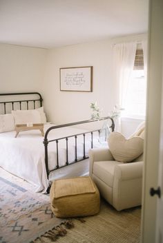 a bedroom with a bed, chair and rug