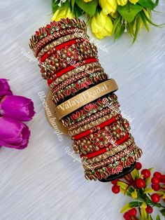 a bunch of bracelets sitting on top of a white table next to yellow flowers