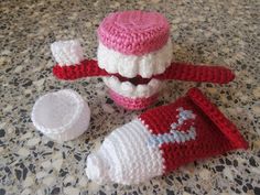 a crocheted hat, mitt and other items sitting on a counter top