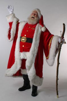 a man dressed as santa claus holding a stick