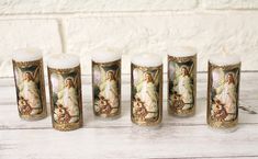 five candles with the image of mary and jesus on them are lined up against a white background