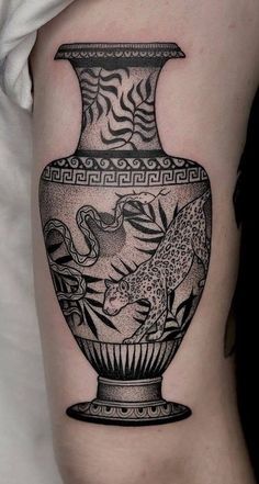 a black and white photo of a vase with animals in it on the left thigh