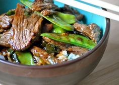 a bowl filled with meat and vegetables on top of a table