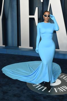 a woman in a blue dress and sunglasses on the red carpet at an oscars event