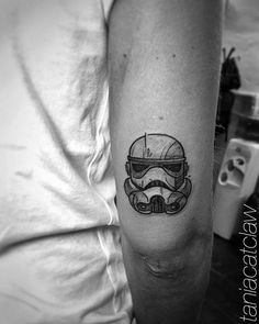 a man's arm with a star wars helmet tattoo on the left inner arm