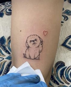 a small dog with a heart tattoo on its leg