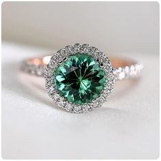 a ring with a green diamond surrounded by white diamonds