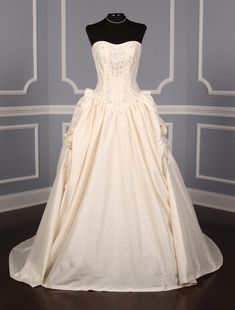 a white wedding dress on display in a room