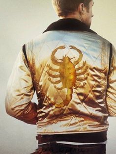 a man wearing a gold jacket with a scorpion on it's back and his hands in his pockets