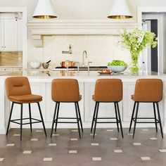 three stools sit in front of a kitchen island