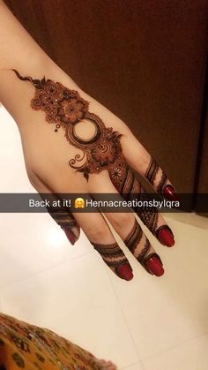 a woman's hand with henna tattoos on it