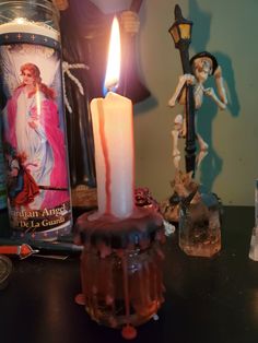 a lit candle sitting on top of a table next to an old fashioned tin can