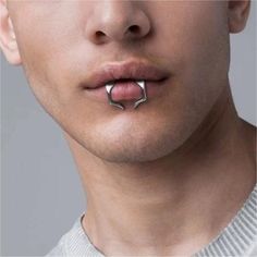 a man with an unusual nose ring in his mouth