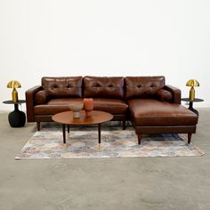 a brown leather couch sitting on top of a rug