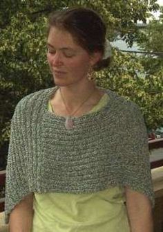 a woman wearing a green dress standing in front of trees