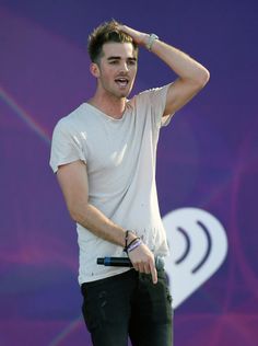 a male in a white shirt and black pants is holding his hand on his head