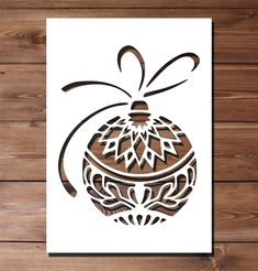 a card with an ornament in the shape of a christmas ball on a wooden background