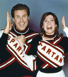 a man and woman in cheerleader outfits posing for the camera with their hands up