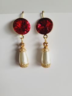 These are real eye catchers!  Beautiful 14mm Swarovski dark ruby red crystals with simple pearl drops, capped with filigree bead caps.  So sparkly!!  Get them while they last, we only made two pairs of these beauties.   Available in gold with ivory pearl drop or gunmetal finish with a white pearl drop. Dangles hang from plated fish hook ear wires.  Total length is 1.85". Jane Seymour Costume, Seymour Costume, Dark Red Jewelry, Red Sapphire, Simple Pearl, Jane Seymour, Anne Boleyn, Red Jewelry, Ivory Pearl