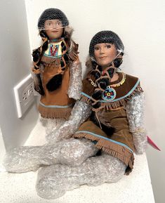 two native american dolls sitting next to each other