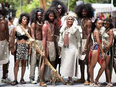 a group of people standing next to each other in native clothing and headdress