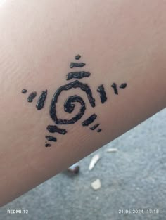 a person with a tattoo on their arm that has an image of a spiral in it