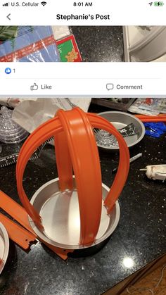 an orange headphones sitting on top of a counter next to plates and utensils